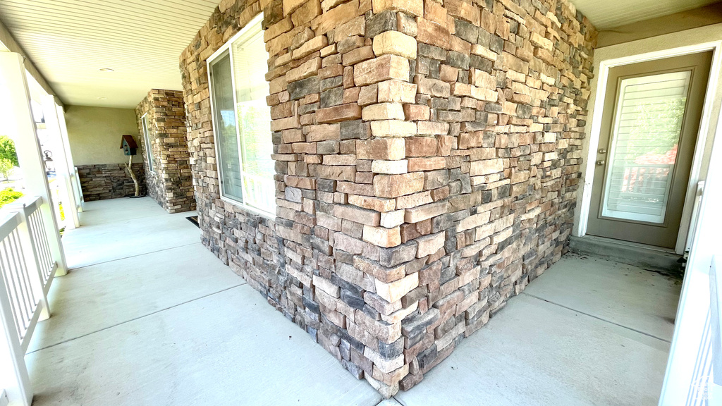 Entrance to property with a porch and stone siding