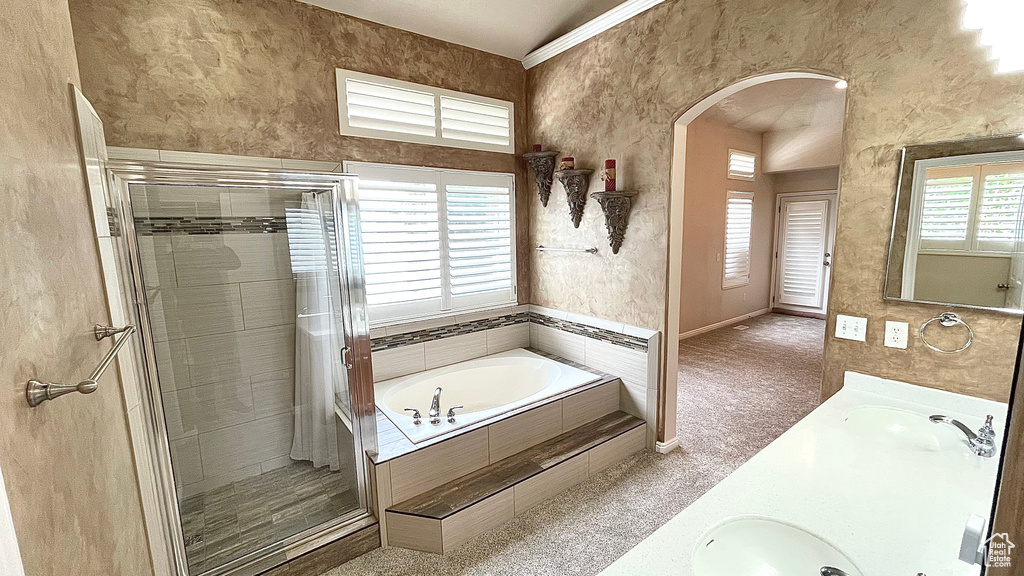 Full bath with a shower stall, a garden tub, double vanity, and baseboards
