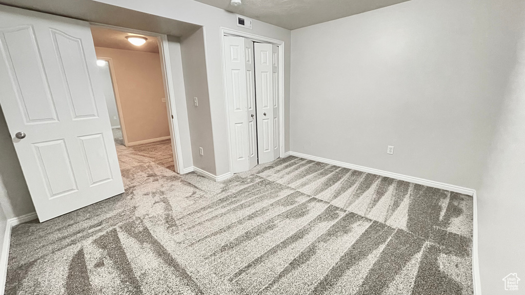 Unfurnished bedroom with carpet, baseboards, and a closet