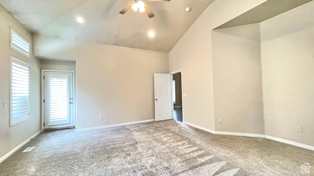 Spare room with carpet flooring, ceiling fan, high vaulted ceiling, baseboards, and recessed lighting