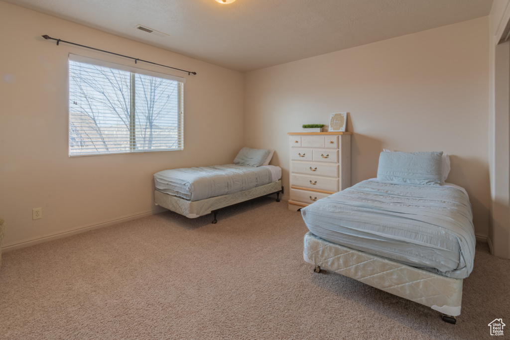 Bedroom with carpet flooring, visible vents, and baseboards