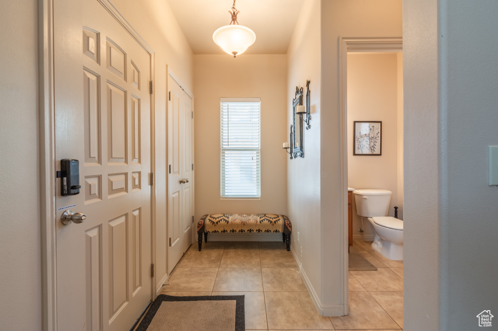 Entryway with light tile patterned flooring and baseboards