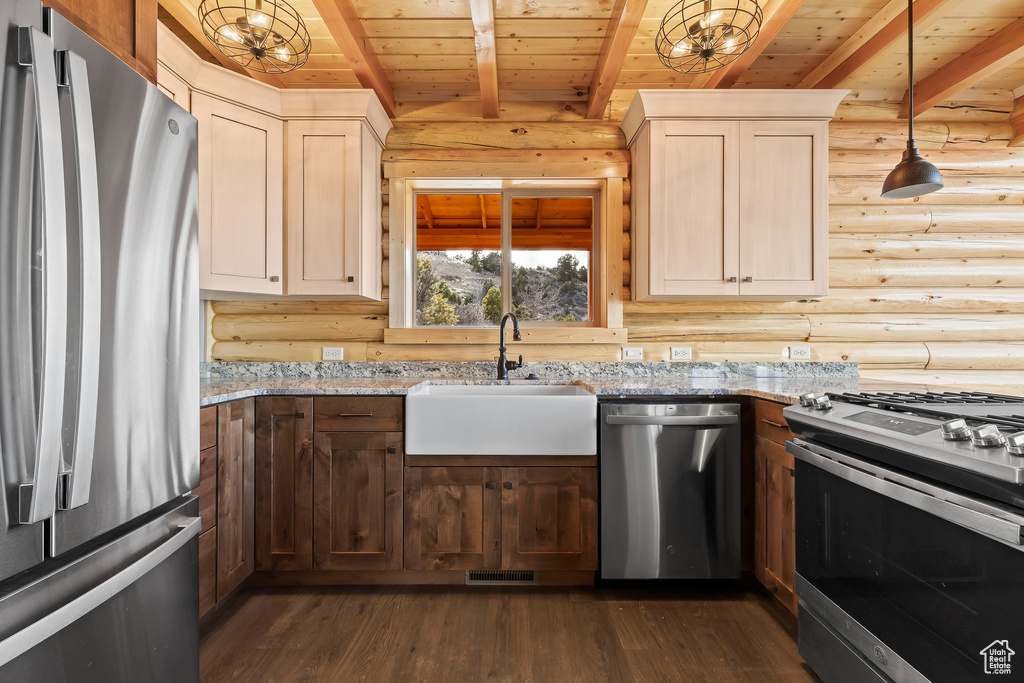 Kitchen with light stone counters, a sink, wood ceiling, appliances with stainless steel finishes, and pendant lighting