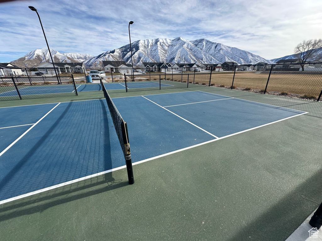 View of sport court featuring fence and a mountain view
