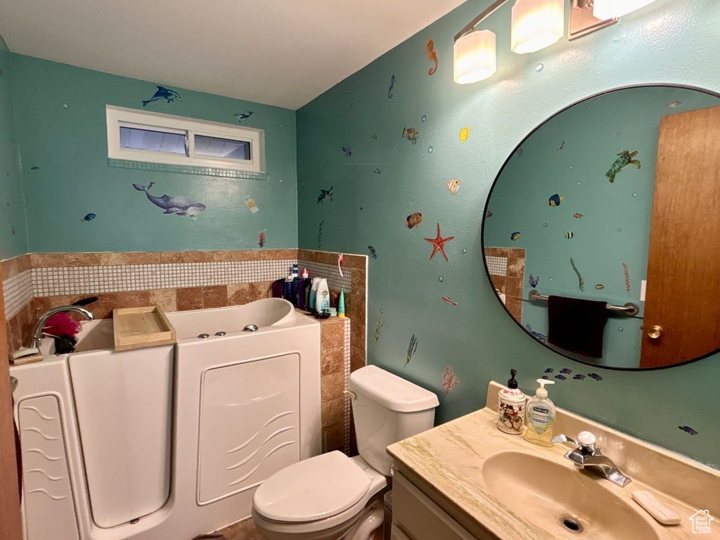 Bathroom with vanity, a garden tub, and toilet