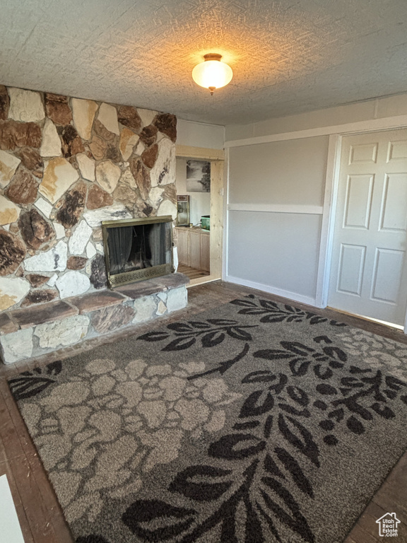 Living area featuring a textured ceiling, a fireplace, and baseboards