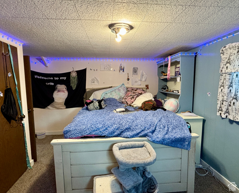 Bedroom featuring dark carpet and baseboards