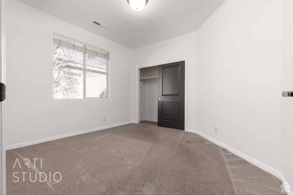 Unfurnished bedroom featuring carpet, baseboards, and a closet