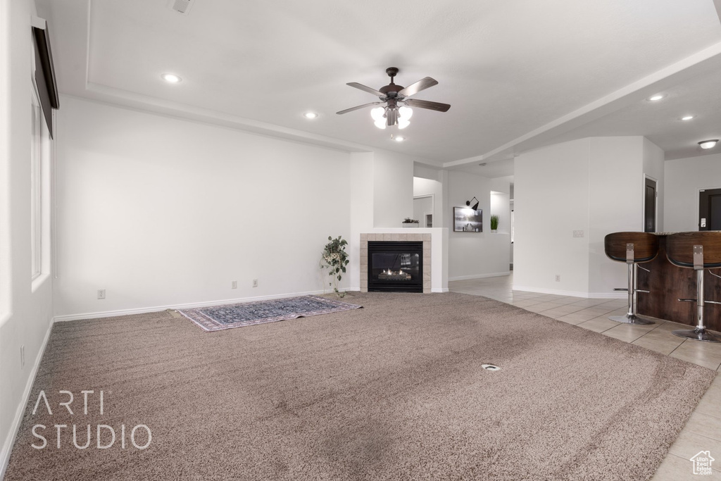 Unfurnished living room featuring recessed lighting, ceiling fan, tile patterned floors, baseboards, and a tiled fireplace