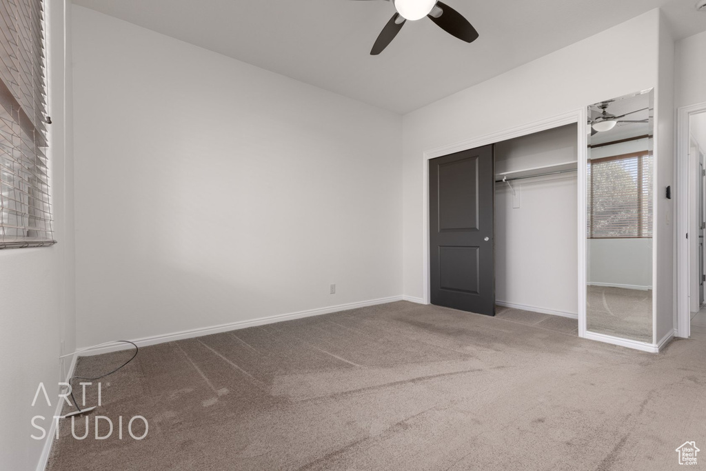 Unfurnished bedroom featuring carpet flooring, baseboards, a closet, and a ceiling fan