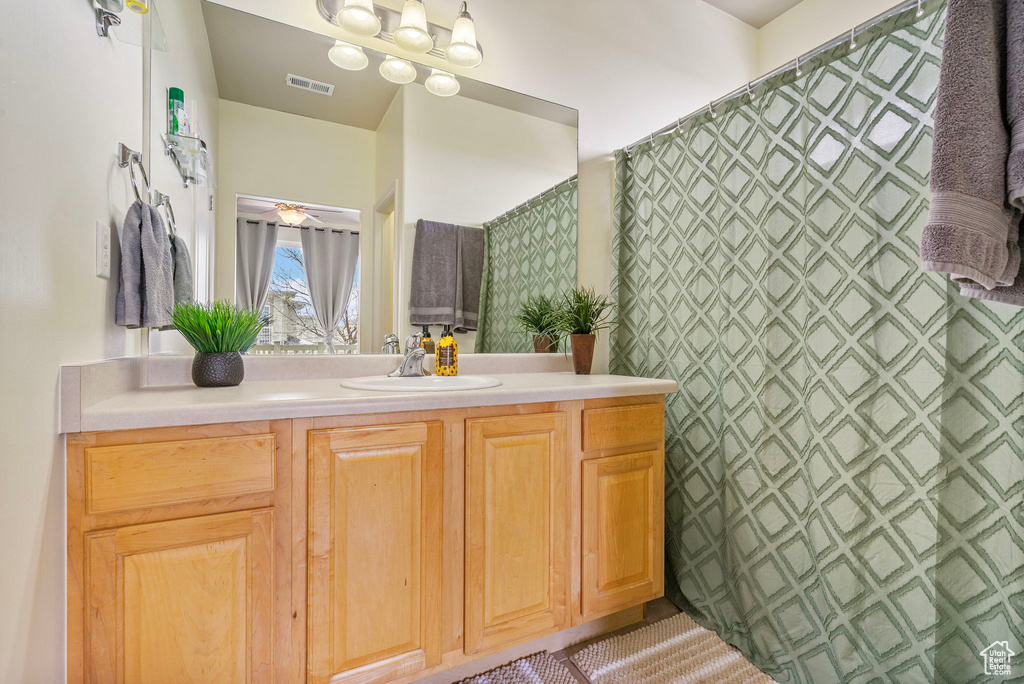 Full bath with visible vents, ceiling fan, and vanity