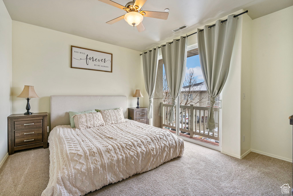 Bedroom with access to exterior, light colored carpet, visible vents, ceiling fan, and baseboards