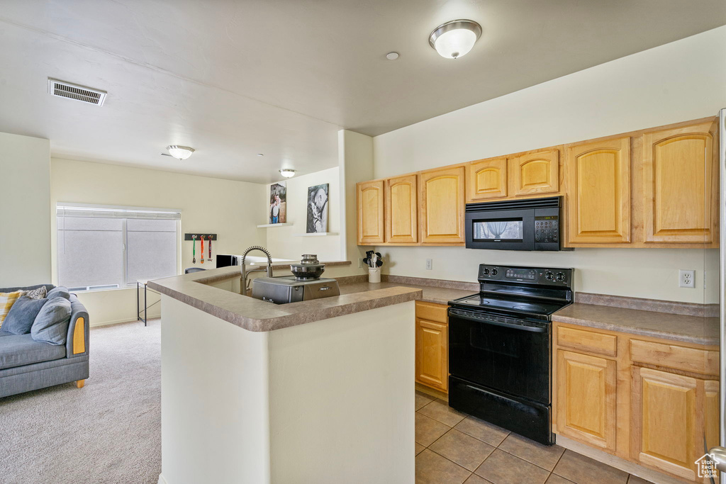 Kitchen with visible vents, open floor plan, a sink, a peninsula, and black appliances