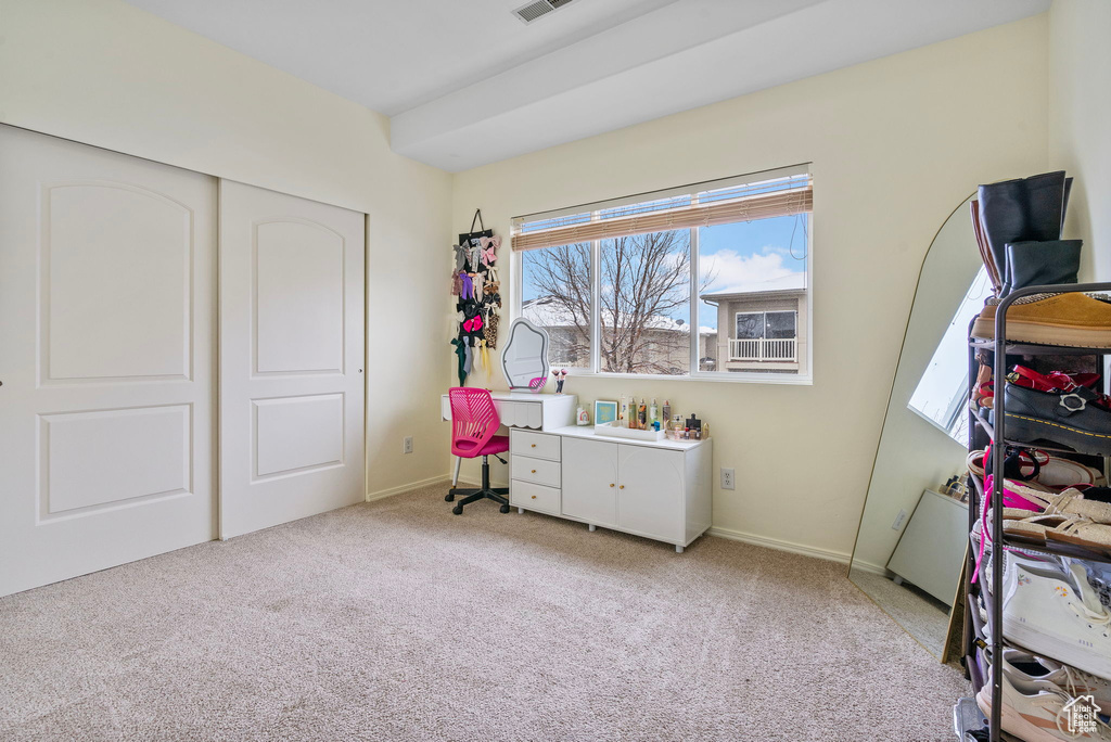 Bedroom featuring a closet, light carpet, and baseboards