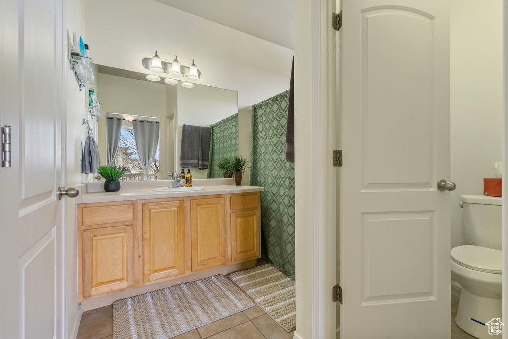 Full bath with tile patterned flooring, vanity, toilet, and wallpapered walls