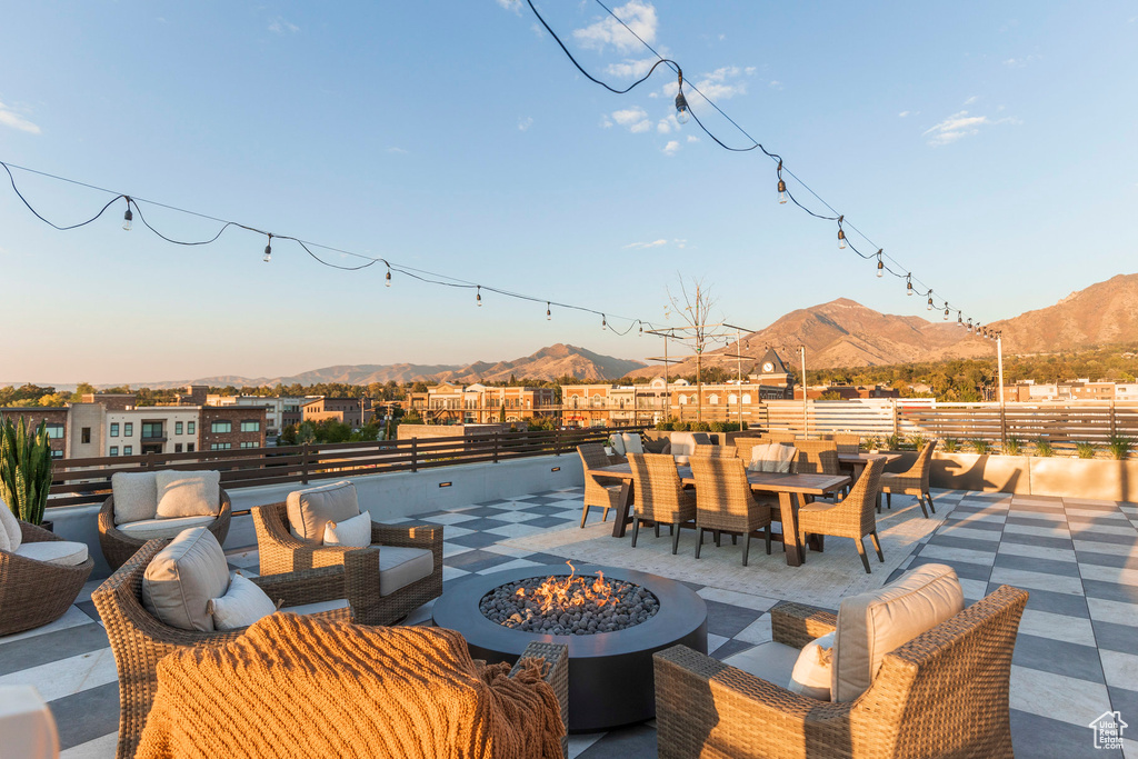 View of patio featuring outdoor dining area, an outdoor living space with a fire pit, and a mountain view
