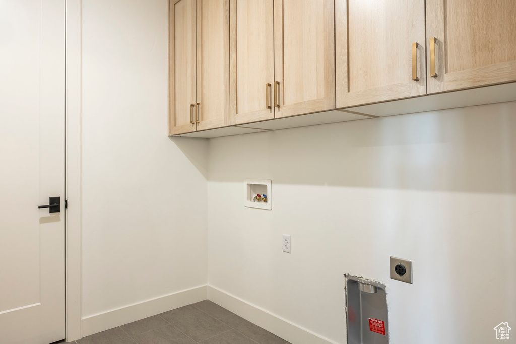 Washroom with hookup for a washing machine, cabinet space, hookup for an electric dryer, and baseboards