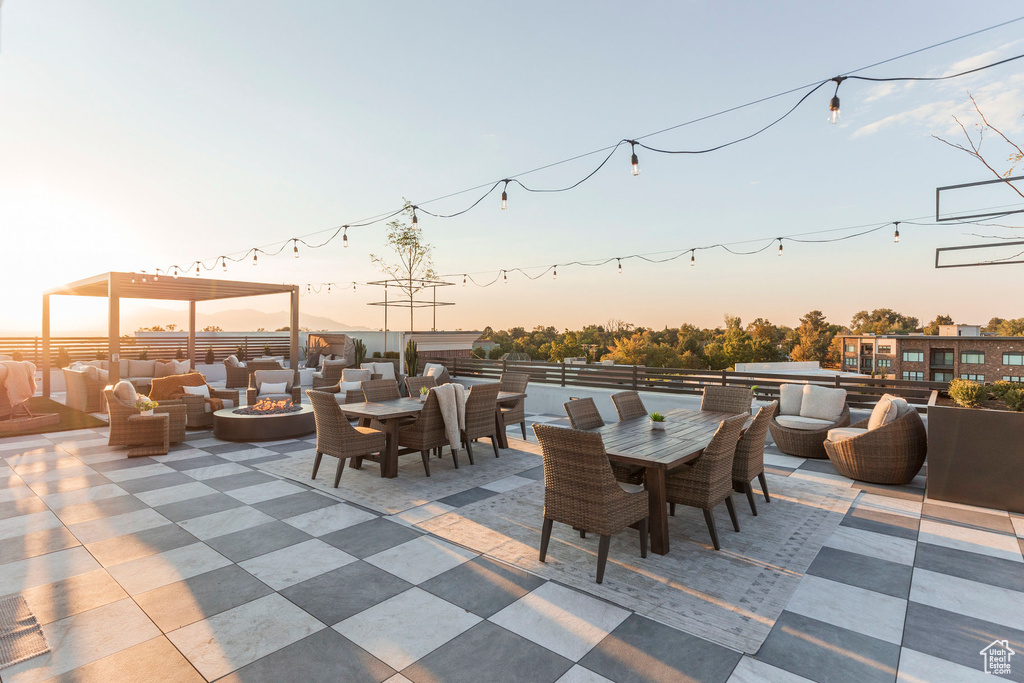 Patio terrace at dusk with outdoor dining area and an outdoor living space with a fire pit