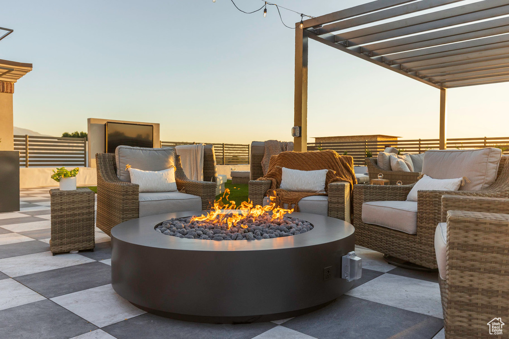 View of patio with an outdoor living space with a fire pit, fence, and a pergola