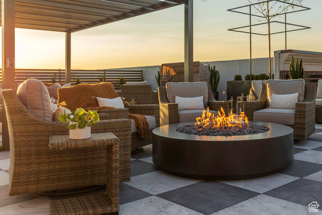 Patio terrace at dusk with an outdoor living space with a fire pit