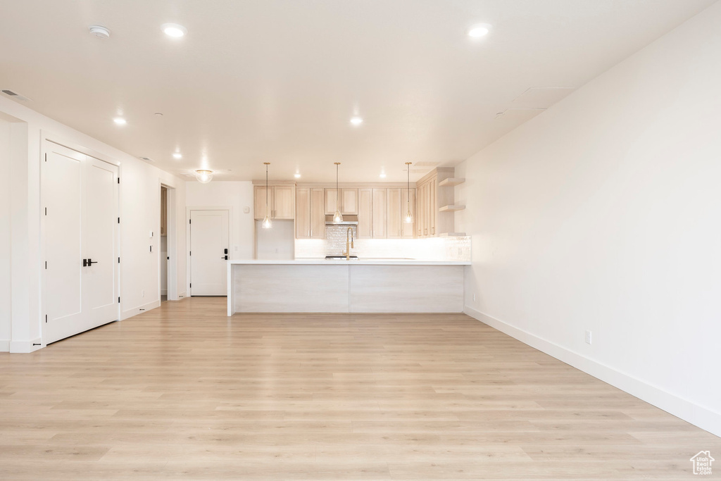 Unfurnished living room featuring light wood-style floors, recessed lighting, and baseboards
