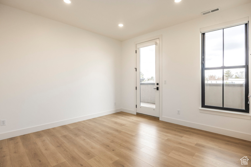 Unfurnished room featuring light wood-style flooring, visible vents, baseboards, and recessed lighting