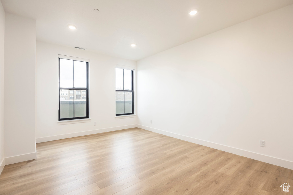 Spare room with light wood-style flooring, visible vents, baseboards, and recessed lighting