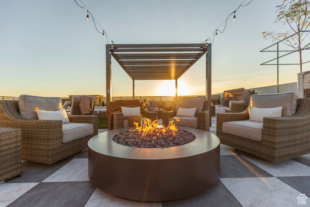 Patio terrace at dusk featuring an outdoor living space with a fire pit and a pergola