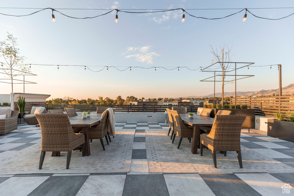Patio terrace at dusk featuring outdoor dining space and fence