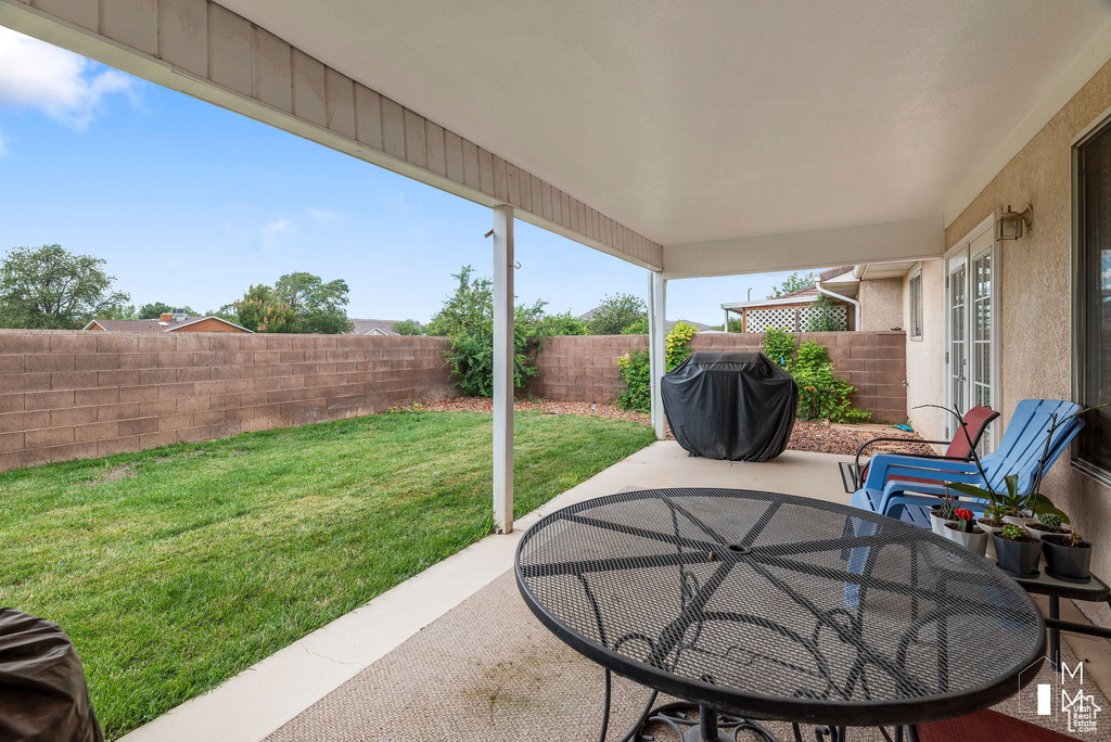 View of patio with outdoor dining space, area for grilling, and a fenced backyard