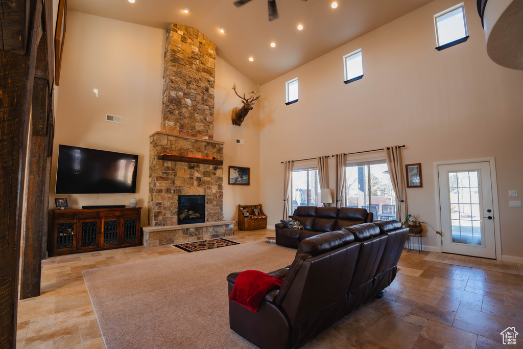 Living area featuring recessed lighting, stone tile flooring, visible vents, a stone fireplace, and baseboards