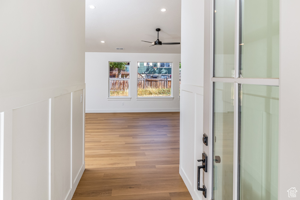 Corridor with baseboards, wood finished floors, visible vents, and recessed lighting