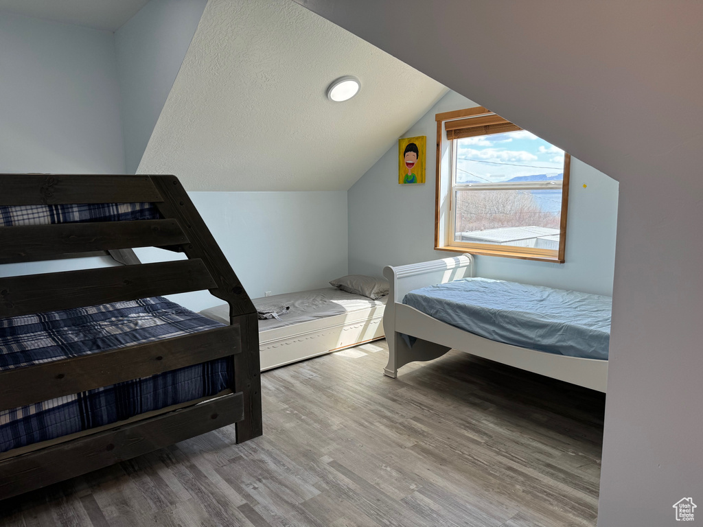 Bedroom featuring vaulted ceiling and wood finished floors