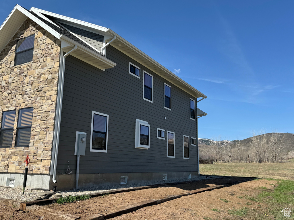 View of side of property with crawl space, stone siding, and a mountain view