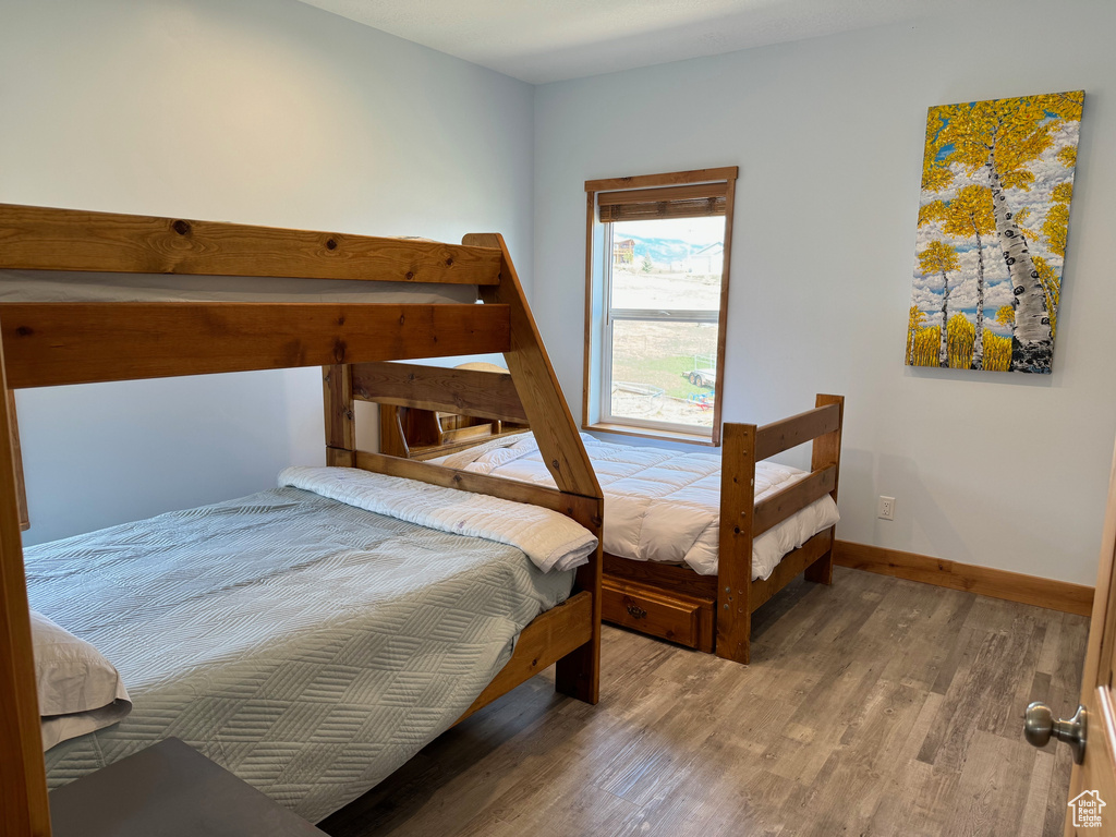 Bedroom with baseboards and wood finished floors