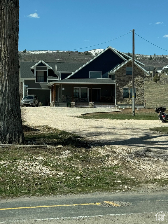 View of front of home featuring stone siding and covered porch