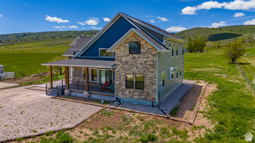 Exterior space featuring covered porch, stone siding, crawl space, and a mountain view