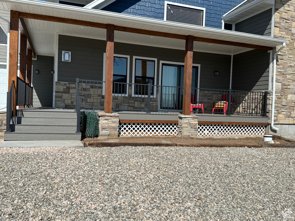 Property entrance with stone siding and a porch