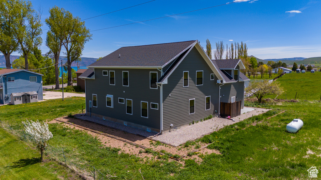 Rear view of property with a yard and a mountain view