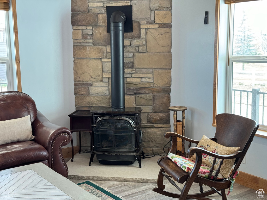 Living area featuring wood finished floors, a wood stove, and baseboards