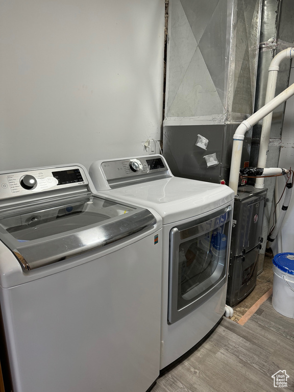 Washroom featuring laundry area, wood finished floors, and independent washer and dryer