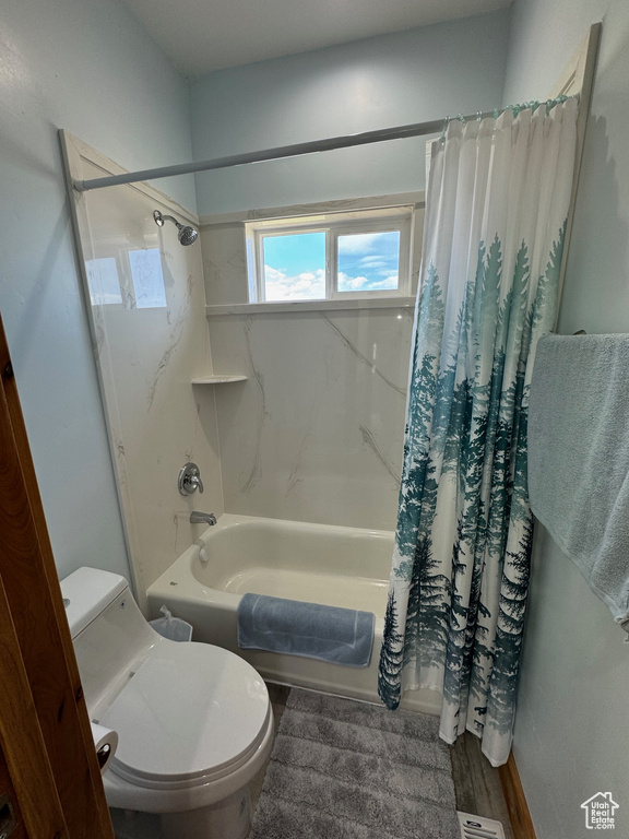 Full bath with shower / tub combo with curtain, toilet, and wood finished floors