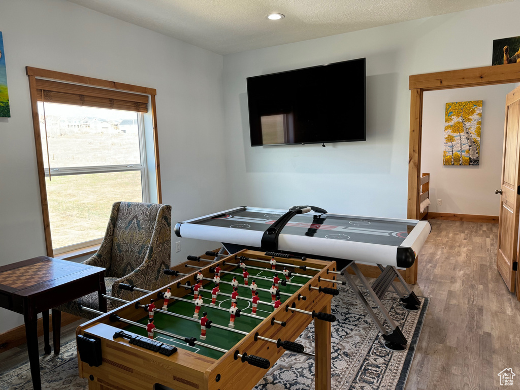 Playroom featuring recessed lighting, a textured ceiling, baseboards, and wood finished floors