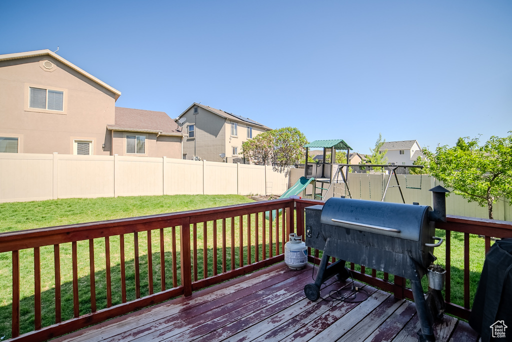 Wooden deck with a playground and a residential view