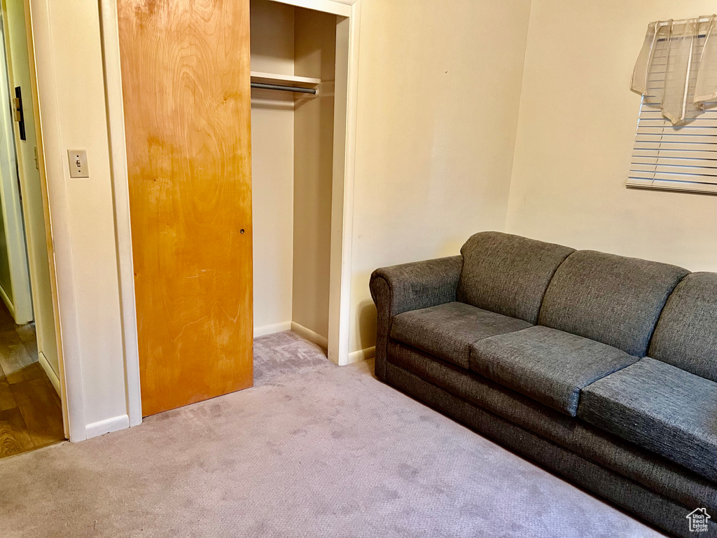 Living area with baseboards and light colored carpet
