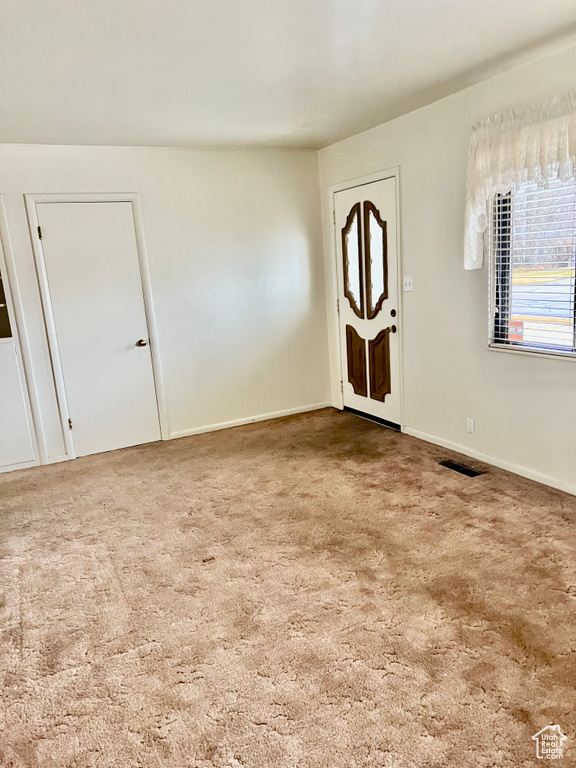 Carpeted entrance foyer with visible vents and baseboards