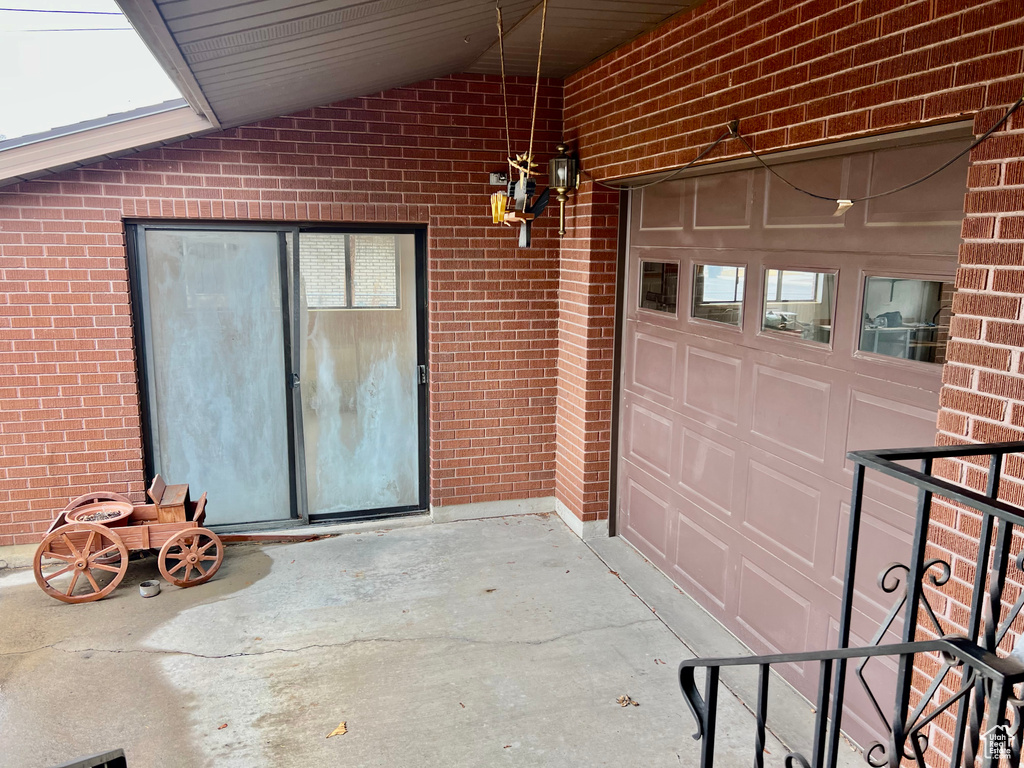 Property entrance with a garage and brick siding