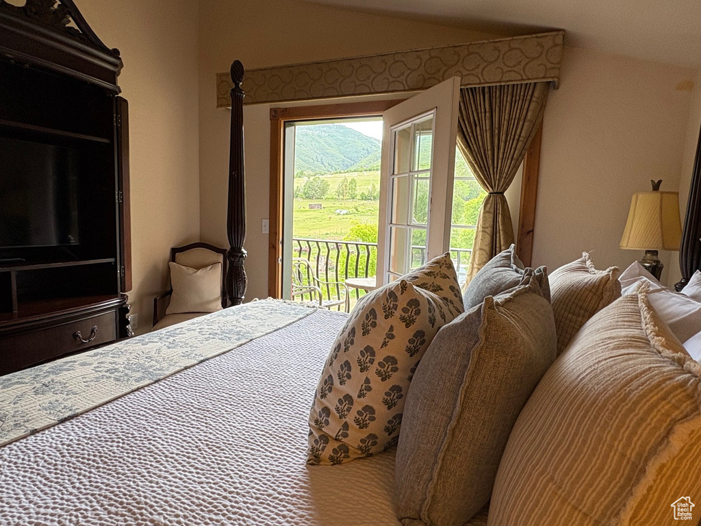 Bedroom with access to exterior and lofted ceiling