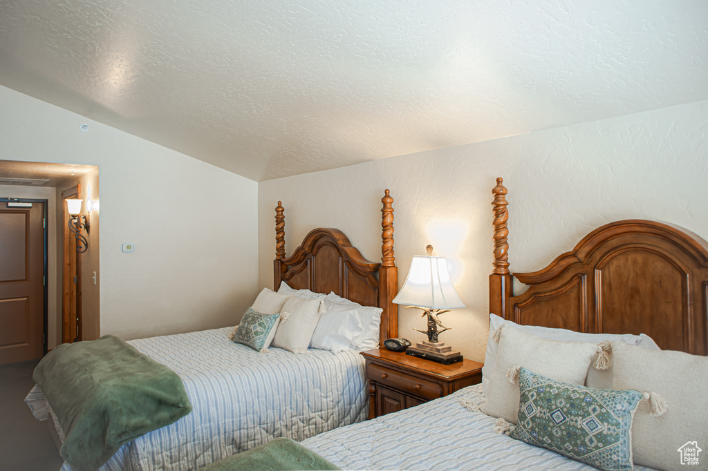Bedroom featuring lofted ceiling and a textured ceiling