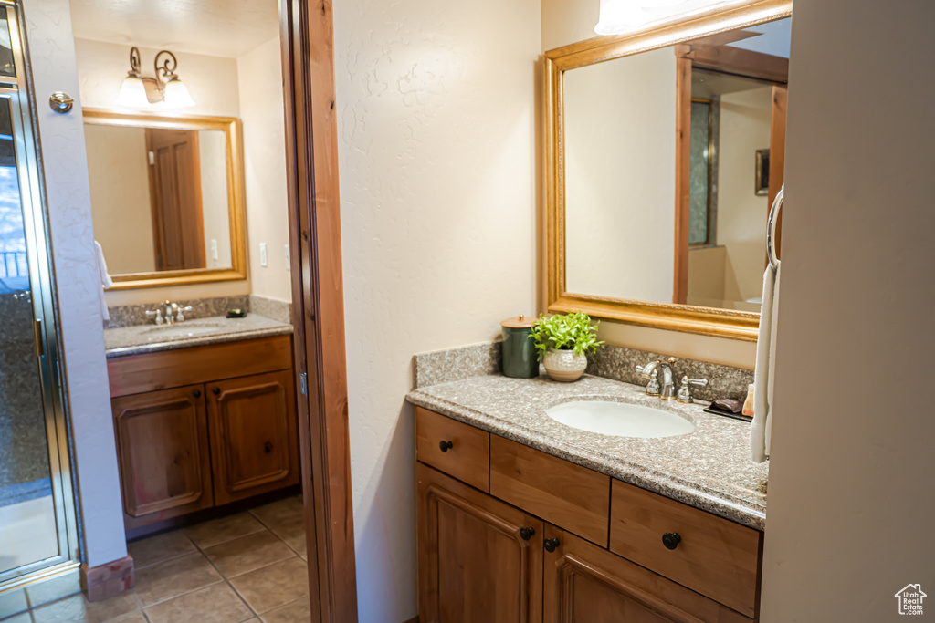 Full bathroom featuring a stall shower, vanity, and tile patterned floors